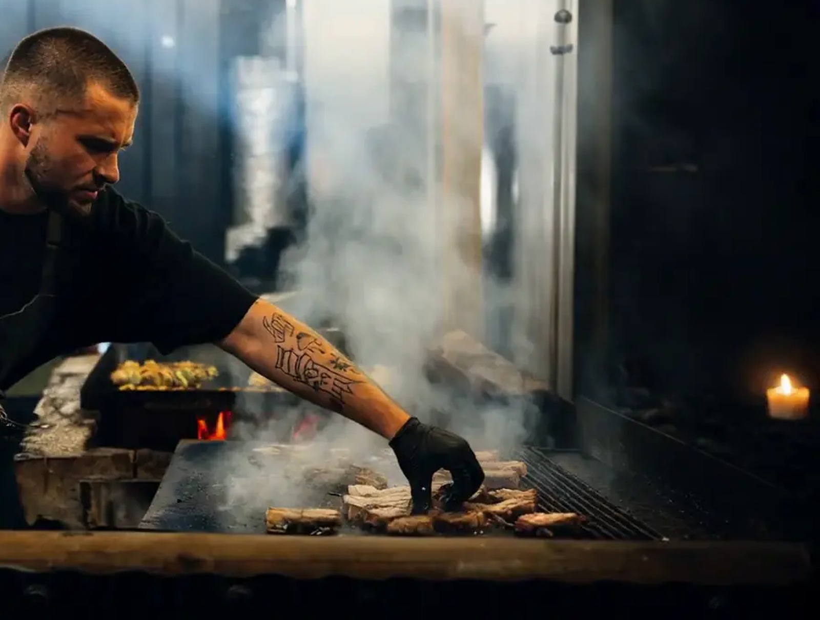 Fire, smoke and a tattooed forearm, frame 121 of the site's hero sequence
