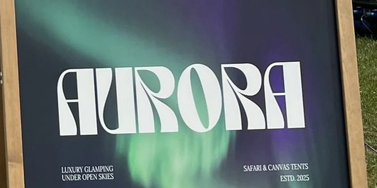 The Aurora A-board photographed in the field, the wordmark set over a green aurora