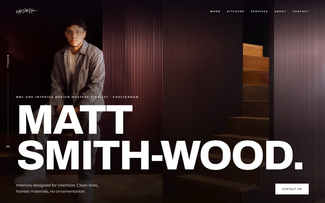 The 2026 homepage: his name at display scale across the figure, over a lamp-lit portrait against fluted panelling, with the navigation and one clear action visible