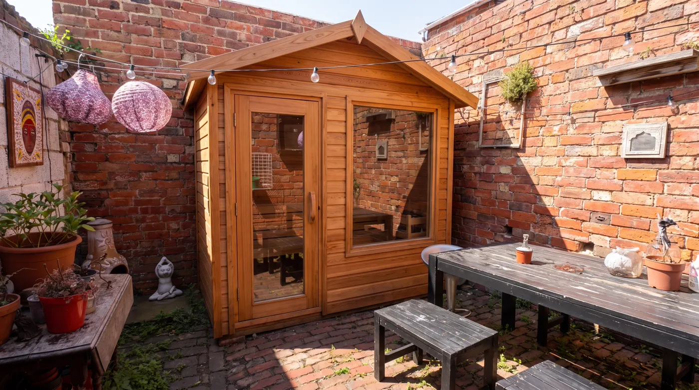 The same walled yard with a cedar sauna designed into it, the brickwork, lanterns, table and plant pots all preserved